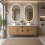 Bathroom with wooden vanity, double oval mirrors, and decorative elements.