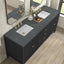 Bathroom vanity with black marble countertop, white sinks, and gold fixtures.