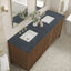 Bathroom vanity with two sinks, dark countertop, and wooden cabinets.