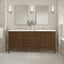 Bathroom vanity with two sinks, mirrors, and decorative elements against a tiled wall.