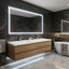 Modern bathroom with wooden vanity, illuminated mirror, and bathtub.
