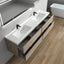 Bathroom vanity with double sink, wooden cabinets, and a bathtub in the background.