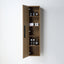 A tall, narrow wall-mounted wooden storage cabinet with an open door, showing four shelves and small toiletry bottles and folded towels inside, photographed against a plain light gray wall.