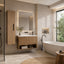 A modern bathroom interior featuring a floating wooden vanity with an integrated sink and backlit mirror, a freestanding bathtub, a tall wood cabinet, and a large window with outdoor greenery visible.
