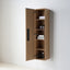 A wall-mounted wooden bathroom cabinet with one door open, showing shelves with towels and toiletries, set against a plain white wall.