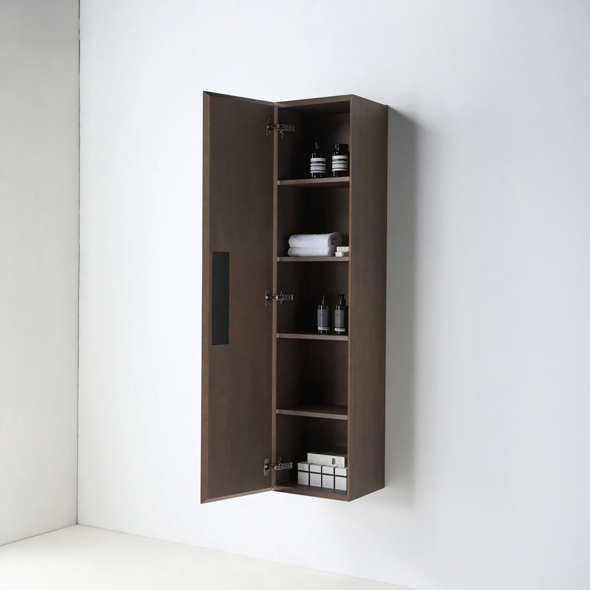 A tall, narrow wall-mounted cabinet in a light natural wood finish with a slim black vertical handle, shown against a plain light gray wall.