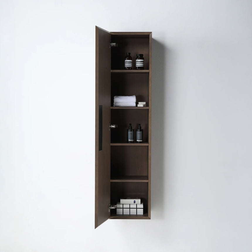 A tall, narrow wall-mounted cabinet in a light natural wood finish with a slim black vertical handle, shown against a plain light gray wall.
