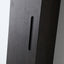 Close-up of a modern dark wood cabinet door featuring a long, narrow recessed handle and a vertical seam.