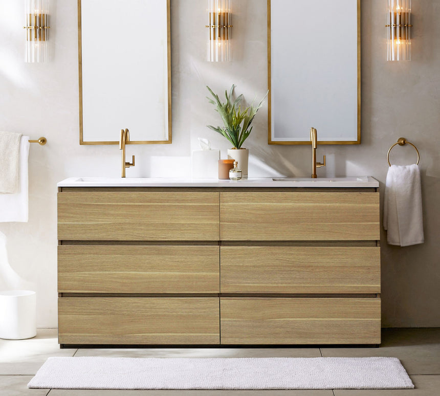 Bathroom vanity with wooden cabinets, white countertop, and gold fixtures.