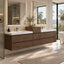 A modern floating bathroom vanity with a dark brown wood finish, integrated white double sinks, and chrome faucets, shown in a bright contemporary bathroom with large mirrors, windows, and a bathtub.