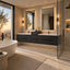 Modern floating double-sink bathroom vanity in a luxury bathroom setting, featuring dark charcoal cabinets, white countertops, large illuminated mirrors, and a glass walk-in shower enclosure.