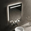 Bathroom vanity with illuminated mirror, sink, and decorative elements.